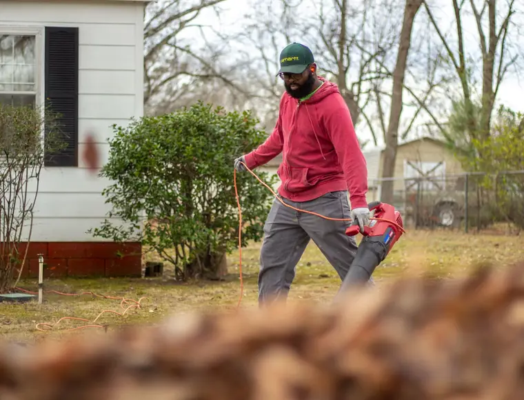 Leaf blower clearing clippings from a driveway