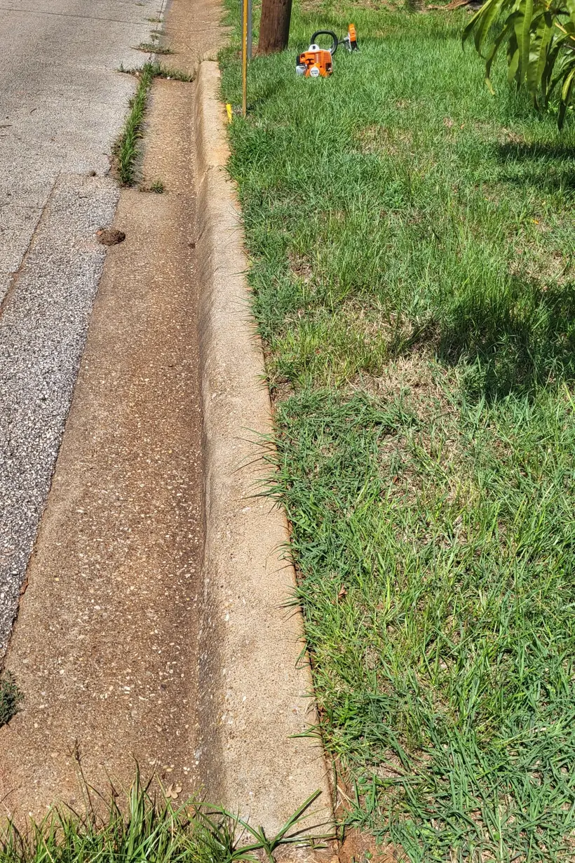 Crisp edge cut along a concrete curb and walkway